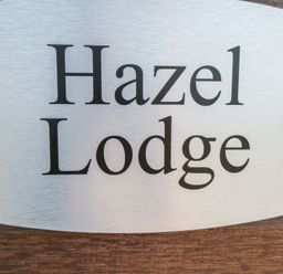 A sign with the name Hazel Lodge