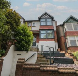 A front view of a two-story house with stairs and plants at Thirty Four By the Sea in Scarborough