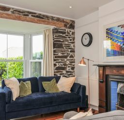 A living room with a sofa and wall art at 2 Glyddins 1910 in Rock