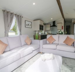A living room with two sofas and a rolled blanket on an ottoman at Stork Lodge in Swannington near Coalville