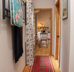 A hallway with a red runner rug leading to a room with chairs and a table at Pink Granite Garden of Ireland near Tinahely County Wicklow