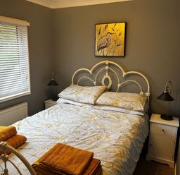 A bedroom with a bed and side table at 22 Two Little Ducks in Lynton