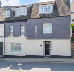 A street view of a two-story house with a tiled roof and multiple windows at Stone's Throw Cottage in Launceston