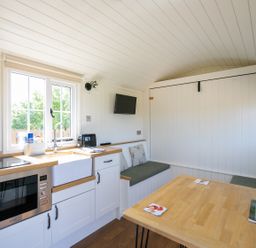 A kitchen and dining area with built in benches and cushions at Strathmore in Burnside near Forfar