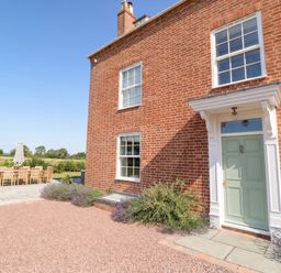An outdoor area with a dining table and chairs at Daniels Farmhouse in Claines