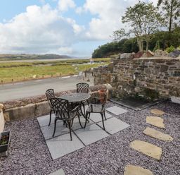 A patio area with a table and chairs at 2 Strand Cottages in Laugharne