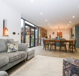 A living room with a sofa and dining area at The Hay Barn in Huntley