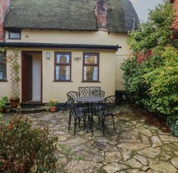A garden with a table and chairs at Bridge Cottage in Budleigh Salterton