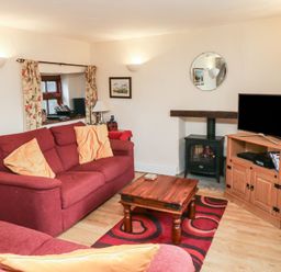 A living room with a sofa and coffee table at Bridge Cottage in Budleigh Salterton