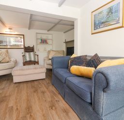 A living room with a sofa and armchair at Greenways in Perranporth