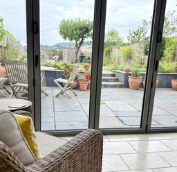 A conservatory overlooking a garden at The Garden Retreat in Winchcombe