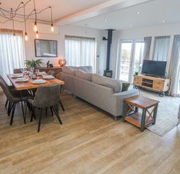 A living room with a dining area and television at Bay View in Portreath