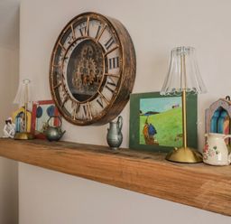 A wooden shelf with a clock, lamp, and decorative items at 6 Bedford Place in Bridport