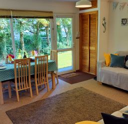 A living room with a dining table and chairs at Driftwood in Dartmouth