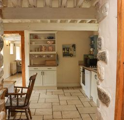 A kitchen with dining table and stone walls at Orchard Barn in Wexford