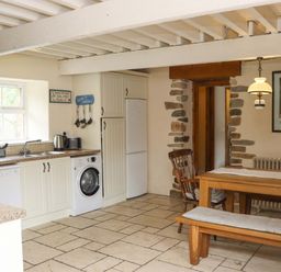 A kitchen with a dining table and appliances at Orchard Barn in Wexford