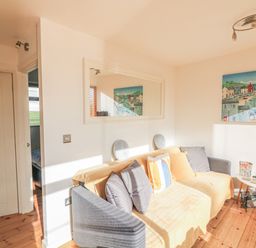 A living room with a gray and beige sofa with cushions a white oval table and a painting on the wall at 418 Norton Park in Dartmouth