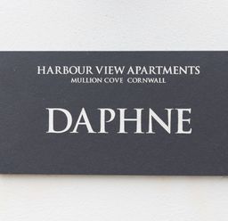 A sign reading Harbour View Apartments Mullion Cove Cornwall Daphne