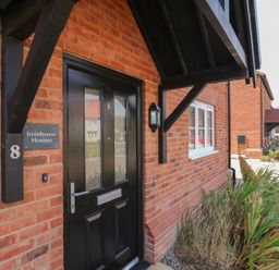 An entrance with a black door and nameplate at Inishnee House in Shotley Gate
