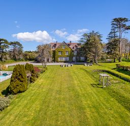 An outdoor area with a house, swimming pool, and trees at Alston Hall Battisborough Cross