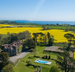 A house with a pool and garden overlooking fields and the ocean at Alston Hall in Battisborough Cross