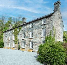 A stone building with windows and a door at Snowdonia Manor in Dolgellau