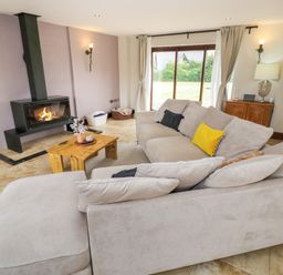 A living room with a fireplace sofa and coffee table at Little Acre Church Lench near Harvington