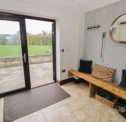 An entrance area with a bench and coat hooks at Little Acre Church Lench near Harvington