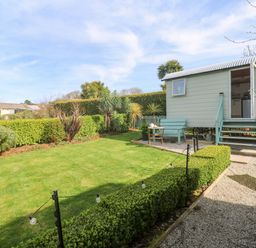 A garden with a shepherd's hut and pathway at Higher Merther Farm Shepherds Hut Helston