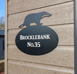 A house sign with a badger figure and the text Brocklebank No 35 on an exterior wall at Brocklebank Lodge 35 High Hesket near Armathwaite