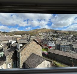 A view of houses and hills from a window at Rothay Cottage Ambleside