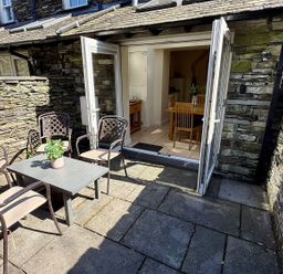 An outdoor patio with a table and chairs at Rothay Cottage in Ambleside