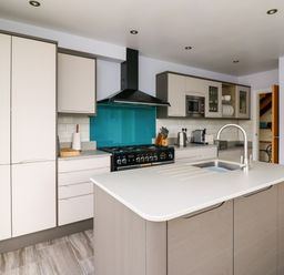 A kitchen with an island countertop sink stove and refrigerator at Carousel in Broad Haven