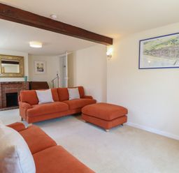 A living room with a sofa and fireplace at Iona Cottage Southwold