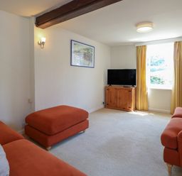 A living room with a television and a sofa at Iona Cottage in Southwold