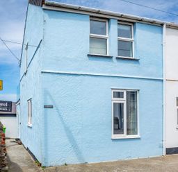 A blue two-story building with windows and a sign reading Victoria House with a signpost nearby saying Bro Dawel no access to beach at Victoria House in Rhosneigr