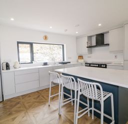 A kitchen with a large island and three stools at Ballyness Bay in Killult Upper near Gortahork County Donegal