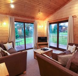 A living room with a sofa and a television at Elderberrys Lodge in Bideford