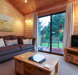 A living room with a sofa and television at Elderberrys Lodge in Bideford