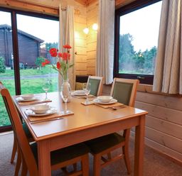 A dining room with a table set for meals at Elderberrys Lodge in Bideford