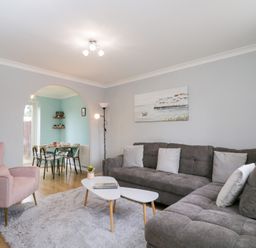 A living room with a grey sofa, armchair, and dining area at 20 Honeycroft Bourton-On-The-Water
