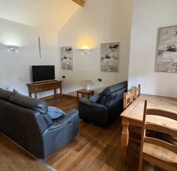 A living room with a sofa and a table at Woodside Cottage in Kerry