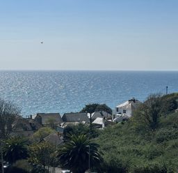 A coastal view with houses trees and the ocean at Waves Edge in Looe