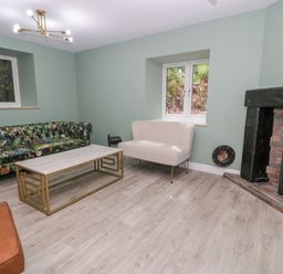 A living room with a sofa and fireplace at Frongoch Old Power House in Dolgellau