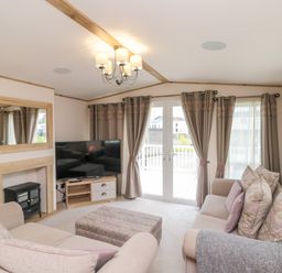 A living room with sofas a television and a fireplace at Drake 11 in Cayton Bay
