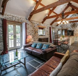 A living room with a sofa and dining table at St Dogwells Barn near Wolfscastle