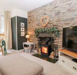 A living room with a fireplace and television at The Wonky Nest in Bowness-On-Windermere