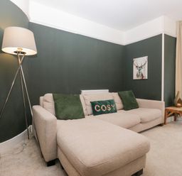 A living room with a sofa and lamp at The Wonky Nest in Bowness-On-Windermere