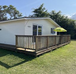 A chalet with a deck and umbrella at Chalet 3 Wipeout in Hayle