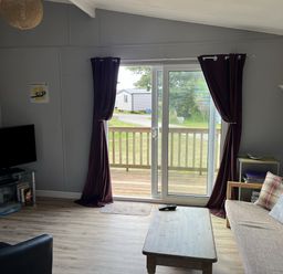 A living room with a television and sofa at Chalet 3 Wipeout in Hayle